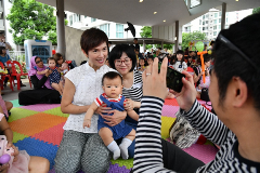 Minister Josephine Teo posing for a photo with a participating family at the Embracing PArenthood Celebrations.