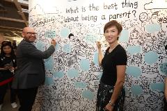 Minister Josephine Teo with IKEA Deputy Managing Director Mike King at the communal wall, where they penned their thoughts on the best thing about being a parent.