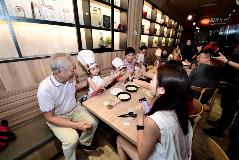 SM Teo and Minister Teo spending time with children and their parents at the Pizza-Making Workshop.